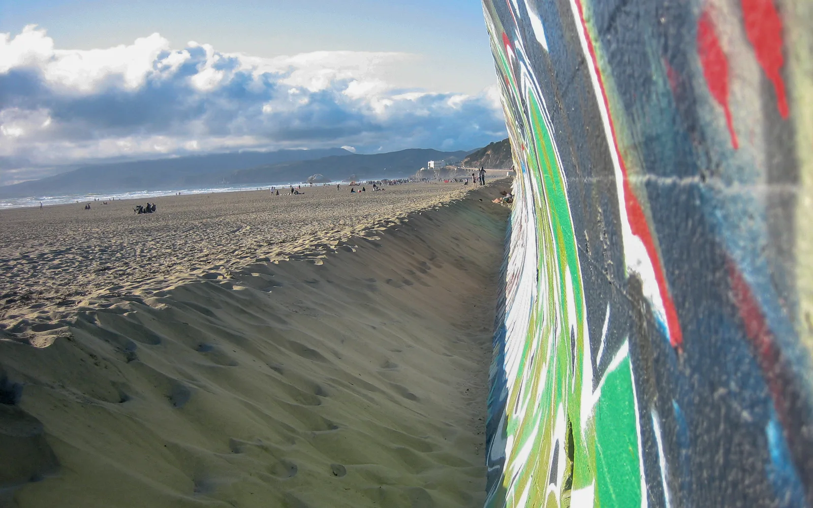 Family enjoying time at ocean beach with clear skies and sandy shoreline